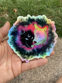a person holding a sticker with an image of a wolf
